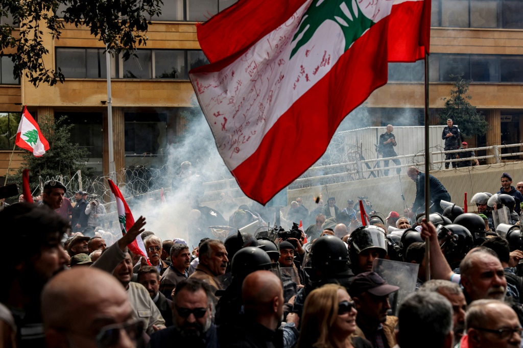    متظاهرون يحتجون على تدهور الأوضاع المعيشية في لبنان فيما تلقي قوات الأمن الغاز المسيل للدموع لتفرقتهم في بيروت في 22 آذار/مارس 2023 (أ ف ب)