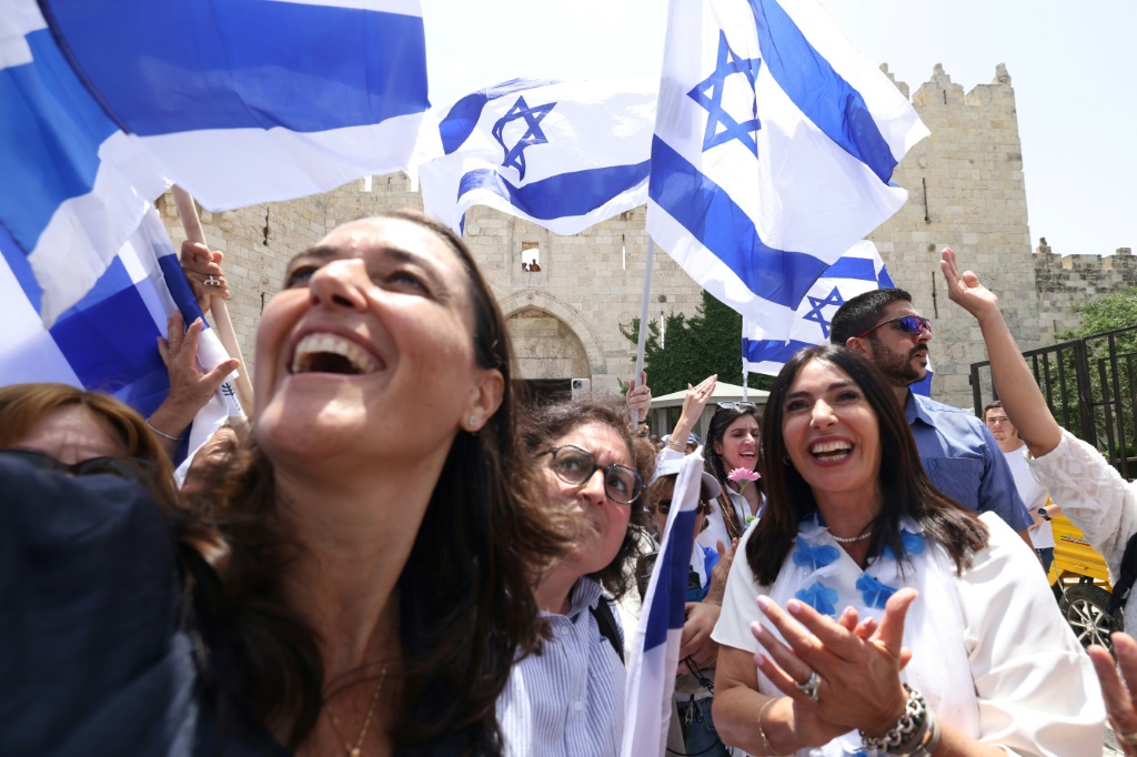    وزيرة النقل ميري ريغيف (يمين) كانت من بين الإسرائيليين الذين يلوحون بالأعلام عند باب العامود في البلدة القديمة بالقدس قبل ساعات من المسيرة (أ ف ب)   