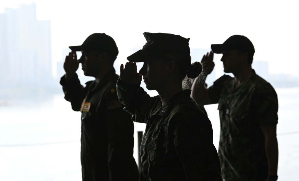 عسكريون خلال مراسم رفع العلم على البارجة الأميركية 