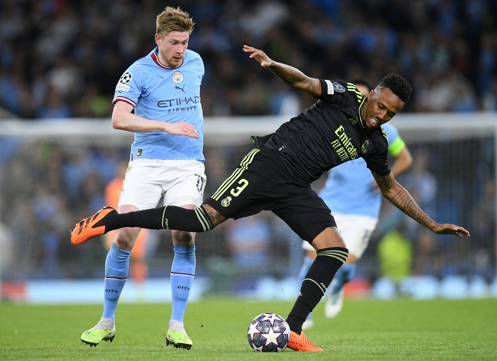  لاعب وسط مانشستر سيتي الانكليزي الدولي البلجيكي كيفن دي بروين (يسار) يحاول مرواغة مدافع ريال مدريد الاسباني الدولي البرازيلي إيدر ميليتاو في اياب نصف نهائي مسابقة دوري أبطال أوروبا في 17 أيار/مايو 2023. (ا ف ب)