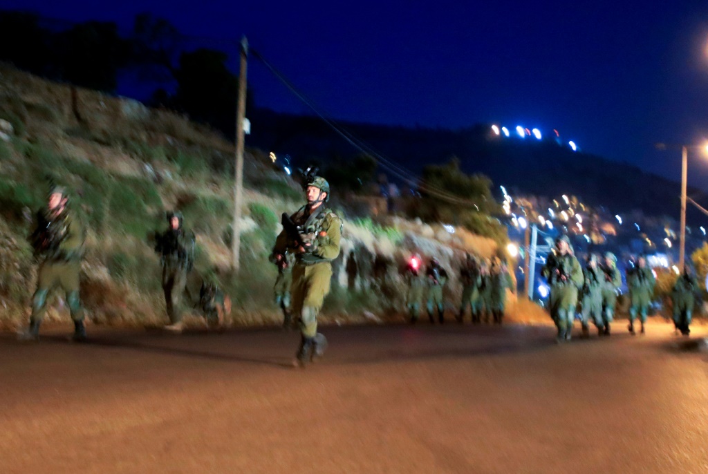    جنود إسرائيليون يخرجون من مخيم بلاطة قرب نابلس بالضفة الغربية المحتلة في ساعة مبكرة الإثنين 22 أيار/مايو 2023 (أ ف ب)