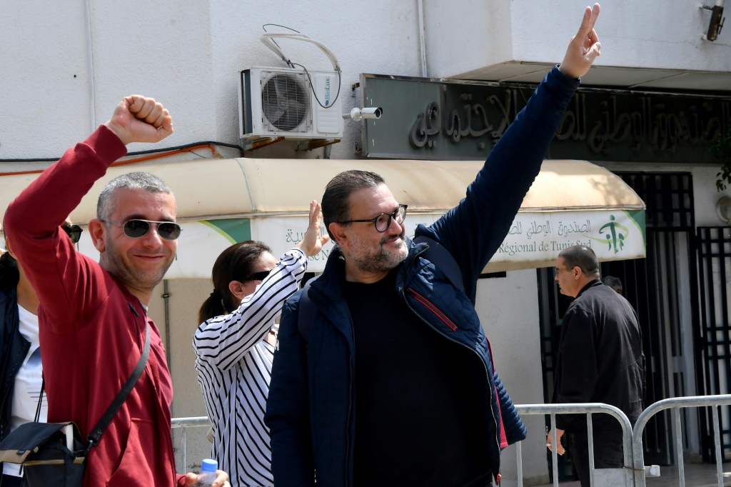     الصحافيان إلياس الغربي (وسط) وهيثم المكي (شمال) قبل الدخول للتحقيق مع الشرطة في العاصمة. تونس في 22 آيار/مايو 2023 (ا ف ب)