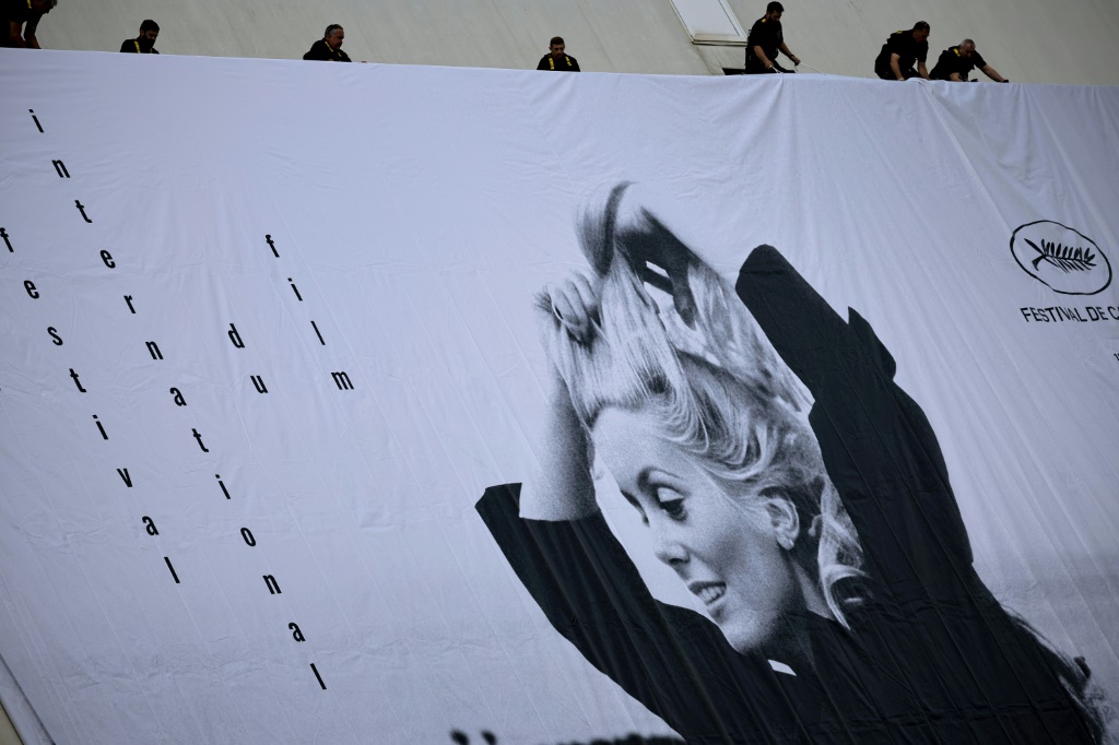 لافتة مهرجان كان السينمائي بنسخته السادسة والسبعين، تظهر فيها الممثلة كاترين دونوف، إثر وضعها على جادة لا كروازيت في المدينة الساحلية الفرنسية في 14 أيار/مايو 2023 (ا ف ب)