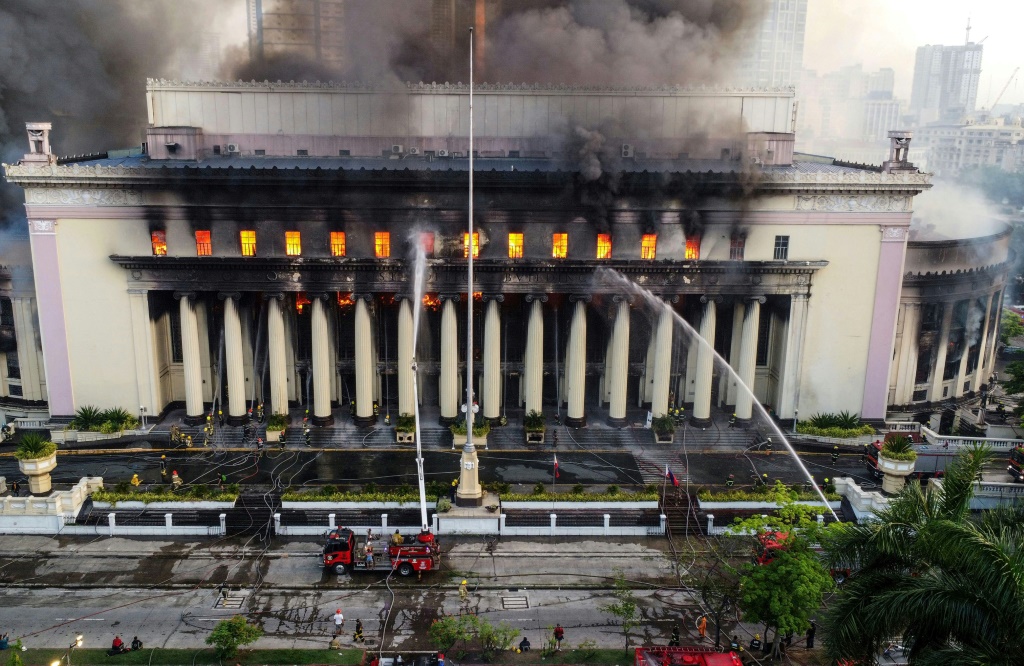 عناصر الإطفاء يحاولون السيطرة على الحريق الذي اندلع في مبنى البريد التاريخي في العاصمة الفيليبينية مانيلا بتاريخ 22 أيار/مايو 2023 (ا ف ب)