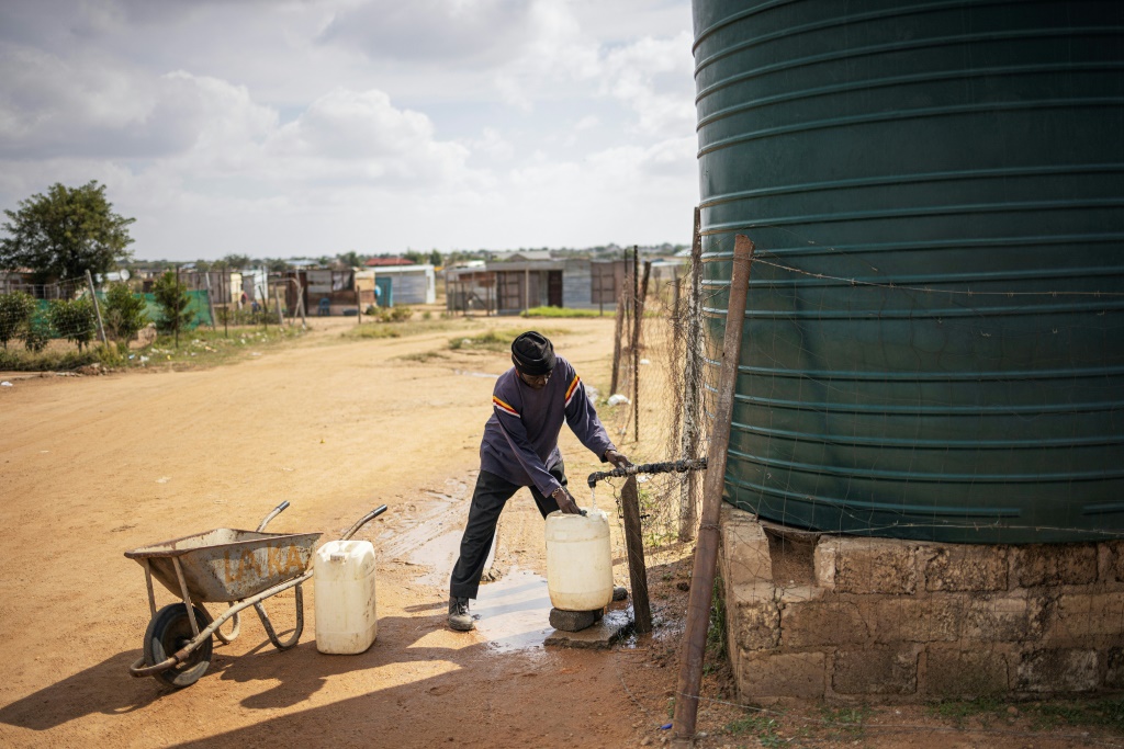 صورة مؤرخة في 23 أيار/مايو 2023 لرجل يجمع المياه من صهريج في بلدة هامانسكرال في جنوب إفريقيا (ا ف ب)