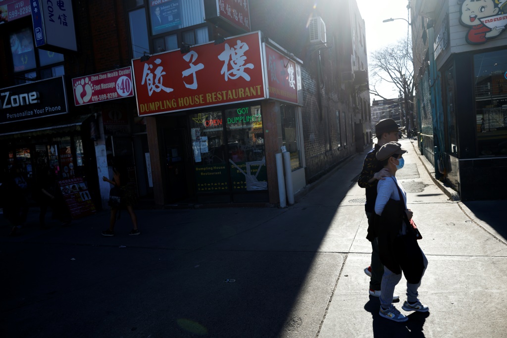    الناس يسيرون في الحي الصيني في تورنتو ، حيث وقع الشتات في تبادل لإطلاق النار بين أوتاوا وبكين (أ ف ب)