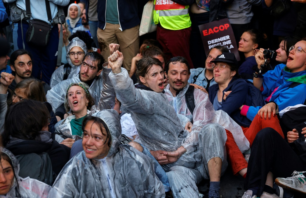 نشطاء مدافعون عن المناخ أثناء مواجهات مع الشرطة التي استخدمت الغاز المسيل للدموع قرب مكان انعقاد الجمعية العامة السنوية لتوتال إنرجي في باريس في 26 أيار/مايو 2023 (ا ف ب)
