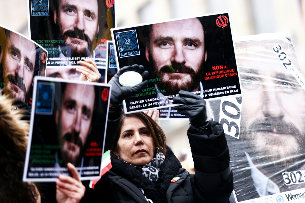 متظاهرون يرفعون لافتات يوم 22 كانون الثاني/يناير 2023 في بروكسل للمطالبة بالإفراج عن العامل الإنساني البلجيكي أوليفييه فانديكاستيل المسجون في إيران (ا ف ب)
