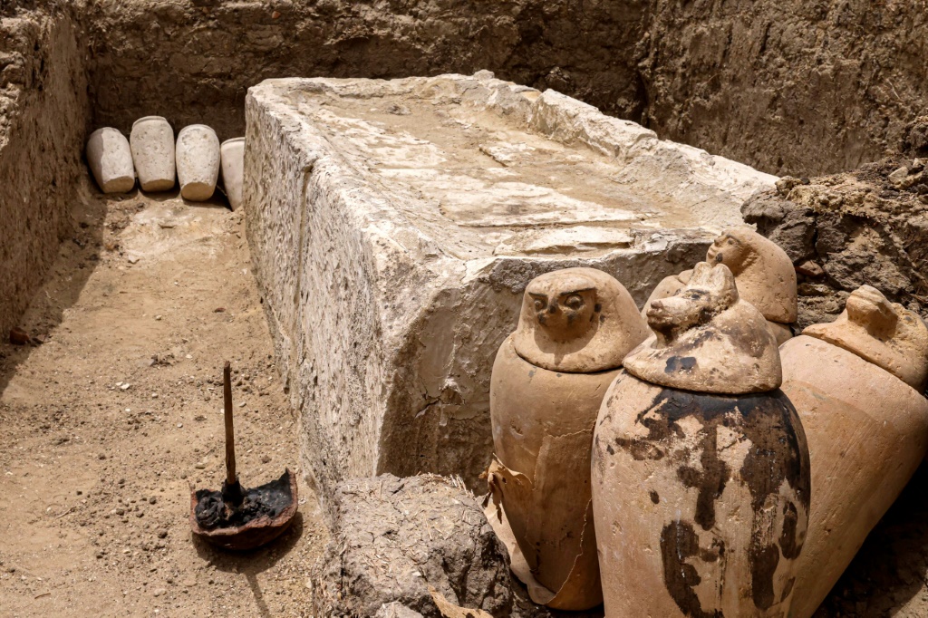 عدد من الأواني ألفخارية والأدوات التي كانت تستخدم في التحنيط قرب سرير حجري للتحنيط في جبّانة سقارة إلى الجنوب من القاهرة في 27 أيار/مايو 2023 (ا ف ب)