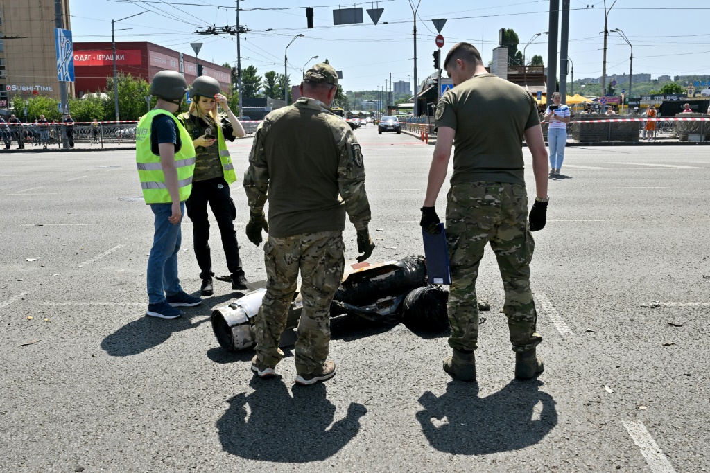    خبراء في الشرطة يفحصون بقايا صاروخ بعد أن استهدفت روسيا العاصمة الأوكرانية كييف (أ ف ب)