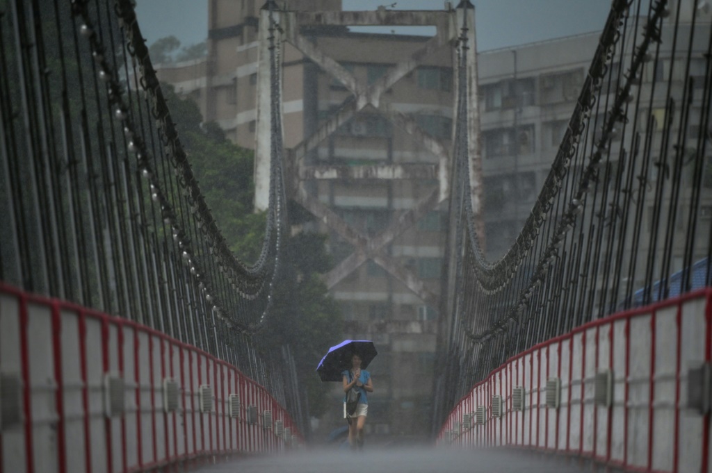 صورة مؤرخة في 31 أيار/مايو 2023 لامرأة تحمل مظلة على أحد الجسور في مدينة تايبيه (ا ف ب)