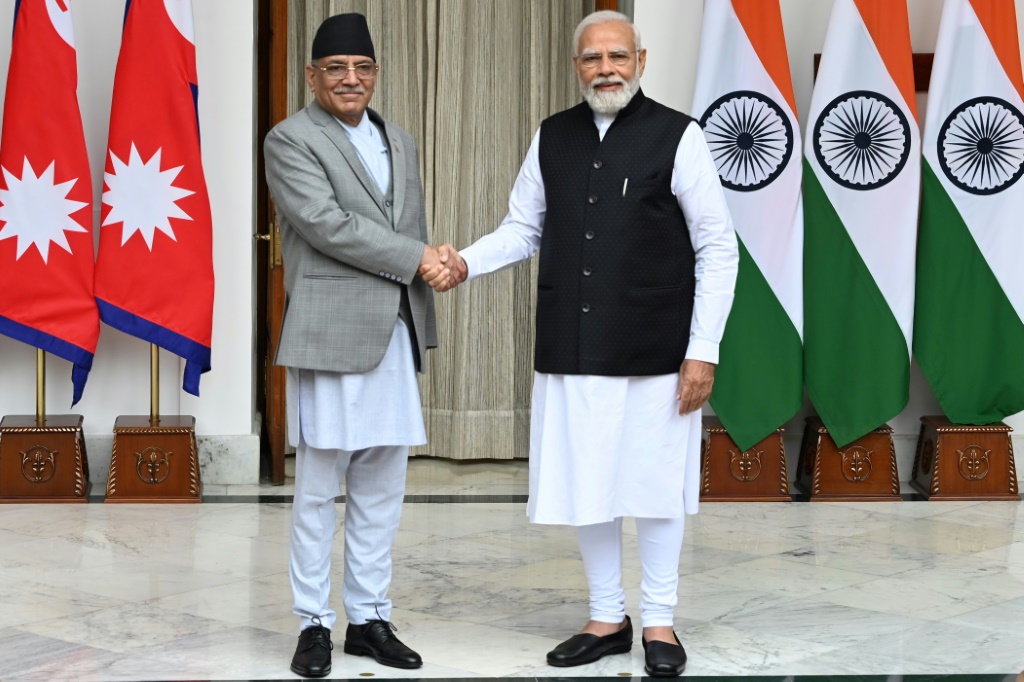رئيس الوزراء الهندي ناريندرا مودي (إلى اليمين) ورئيس الوزراء النيبالي بوشبا كمال داهال يتصافحان قبل اجتماعهما في نيودلهي. (أ ف ب)   