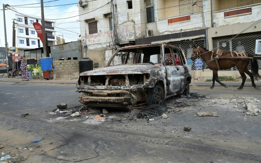     حطام سيارة بعد ليلة أخرى من العنف في داكار (أ ف ب)