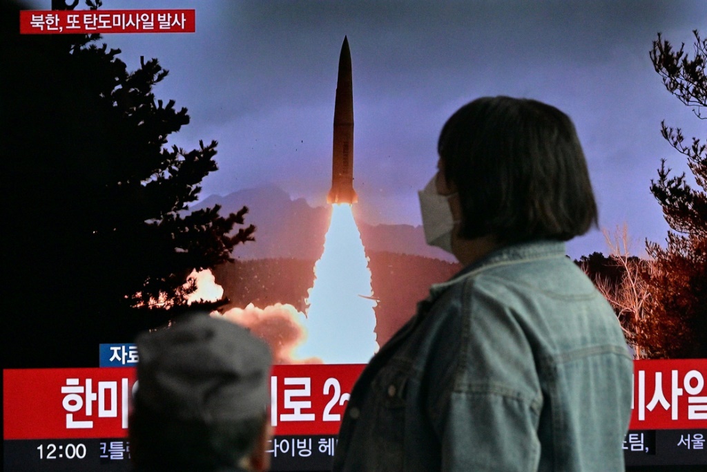 امرأة تمر أمام بث تلفزيوني يظهر مشاهد من تجربة صاروخية كورية شمالية، في محطة قطارات في سيول في 19 آذار/مارس 2023 (ا ف ب)