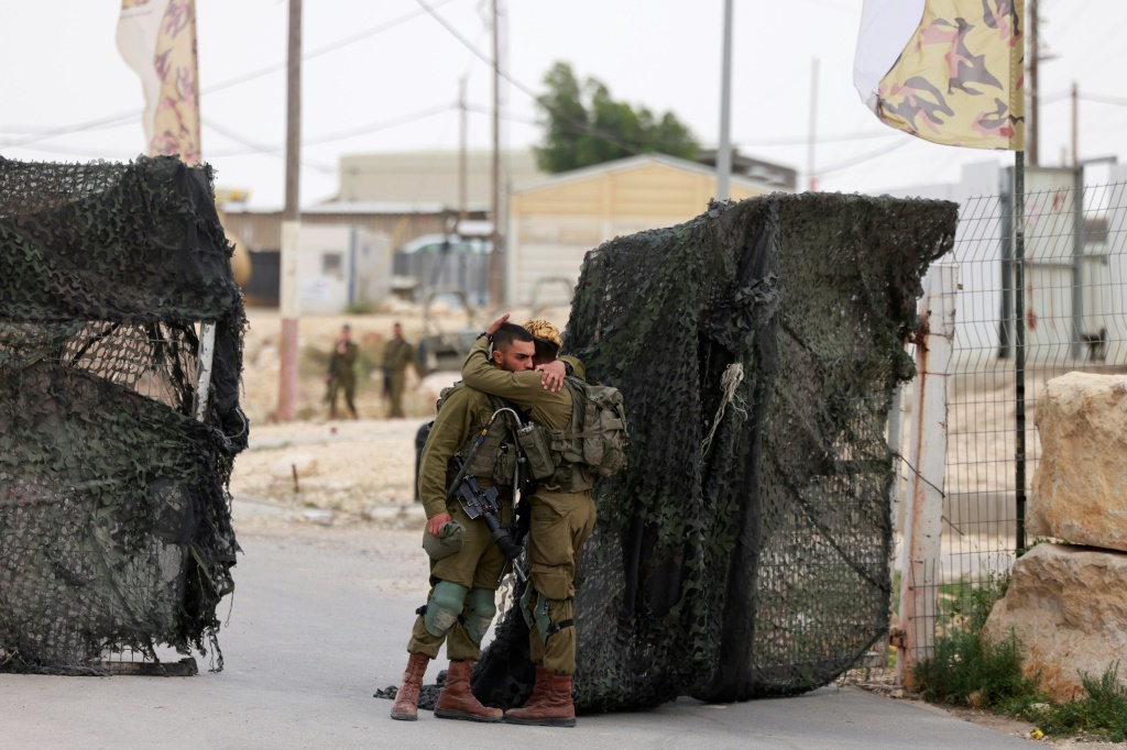     جنود إسرائيليون يواسون بعضهم البعض قرب قاعدة حاريف العسكرية الإسرائيلية على الحدود مع مصر حيث يشتبه بإقدام عنصر أمن مصري على قتل ثلاثة جنود إسرائيليين في حادثة خطيرة ونادرة وقعت في الثالث من حزيران/يونيو 2023 (أ ف ب)