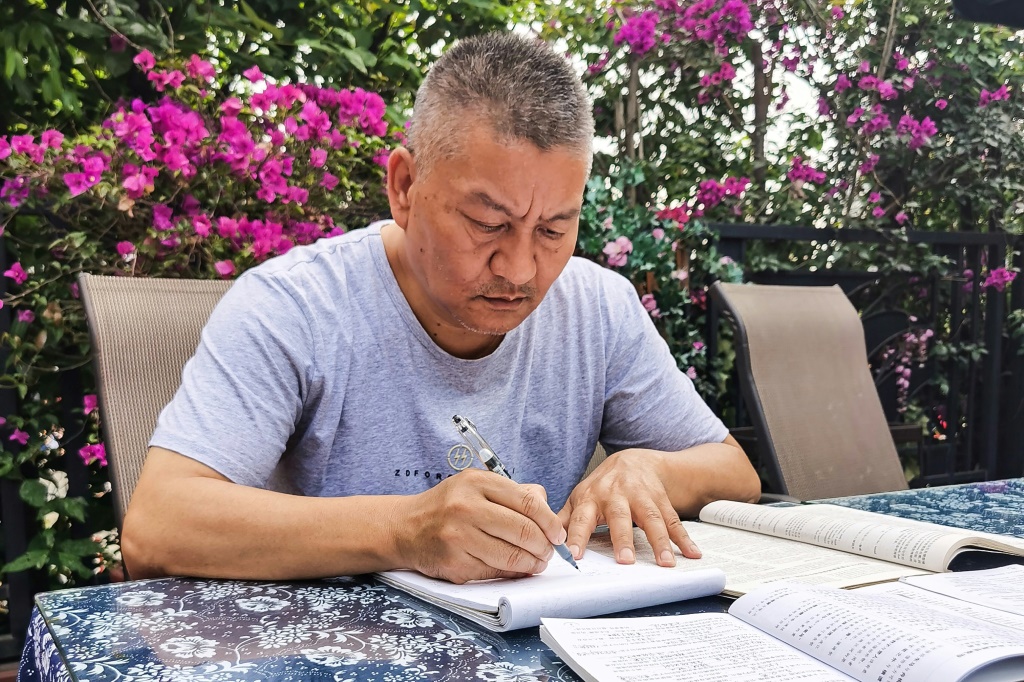 المليونير الصيني ليانغ شي (56 عاماً) يذاكر في 25 أيار/مايو 2023 في منزله في شينغدو بجنوب غرب الصين استعداداً لامتحانات "غاوكاو" المساوية للثانوية العامة التي يتقدم إليها للمرة السابعة والعشرين (ا ف ب)