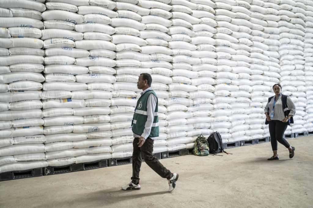 موظفون من برنامج الأغذية العالمي يمرون من أمام أكياس القمح في مخزن في أداما في إثيوبيا بتاريخ 12 كانون الثاني/يناير 2023 (ا ف ب)
