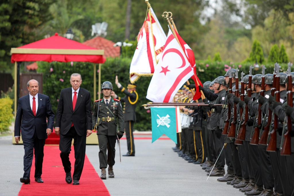 الرئيس التركي رجب طيب أردوغان (يمين) يسير جنبًا إلى جنب مع زعيم جمهورية شمال قبرص التركية المعلنة من جانب واحد ، إرسين تتار ، خلال زيارته بعد الانتخابات إلى نيقوسيا (أ ف ب)   