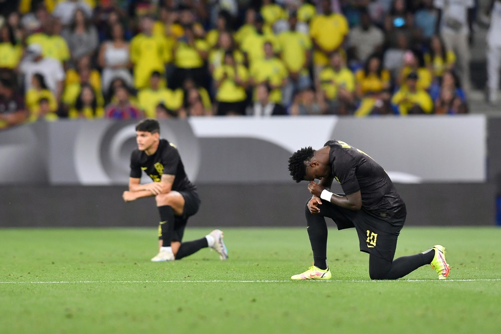 البرازيلي فينيسيوس جونيور يثجو على ركبته احتجاجًا على العنصرية قبل المباراة الودية للبرازيل ضد غينيا في برشلونة في 17 حزيران/يونيو 2023 (ا ف ب)