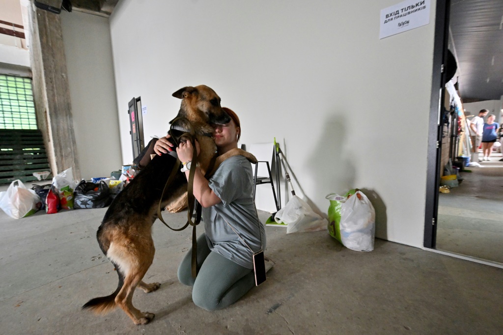     كلب ومتطوعة داخل مأوى للحيوانات في العاصمة الاوكرانية كييف بتاريخ 15 حزيران/يونيو 2023 (أ ف ب)