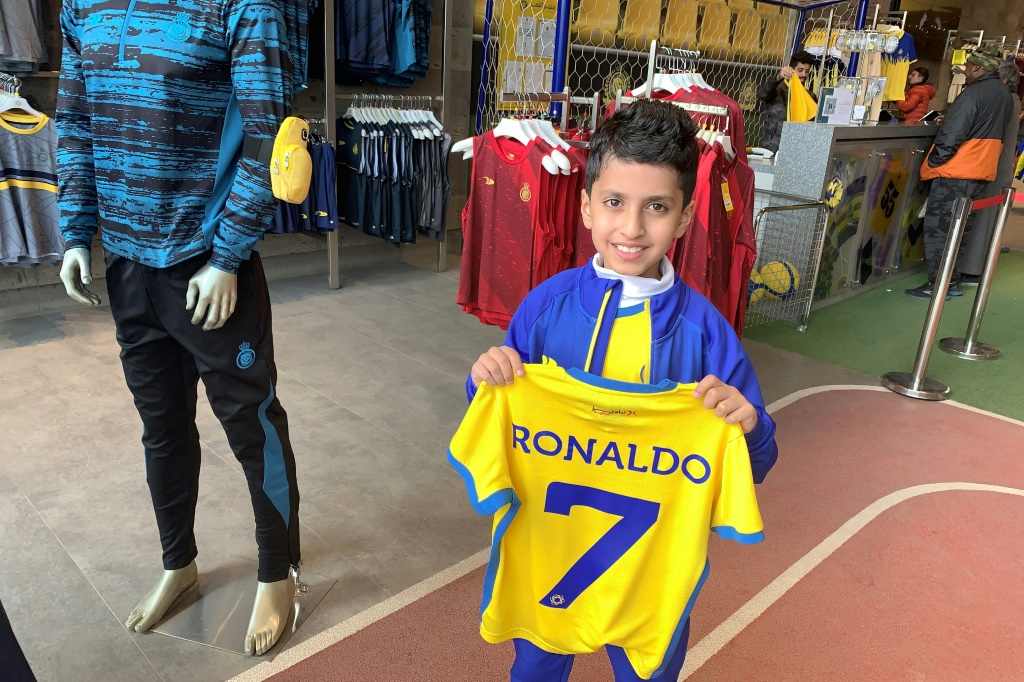 نايف العيبان (9 سنوات) يمسك قميص النصر السعودي الذي يحمل اسم رونالدو ورقم 7 في متجر النادي في الرياض في 31 كانون الأول/ديسمبر 2022 (ا ف ب)