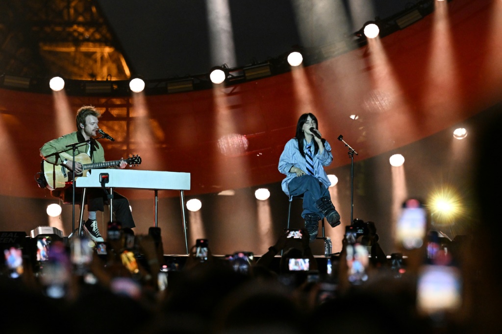 المغنية الأميركية بيلي إيليش (إلى اليمين) وشقيقها فينياس خلال حفلة "غلوبال سيتيزن" أمام برج إيفل في باريس في 22 حزيران/يونيو 2023 (ا ف ب)