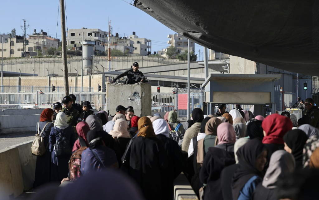 مصلون فلسطينيون مسلمون يتجمعون عند معبر قلنديا الخاضع للاحتلال الإسرائيلي أثناء محاولتهم العبور إلى مدينة القدس في 15 نيسان/أبريل 2022 (أ ف ب)