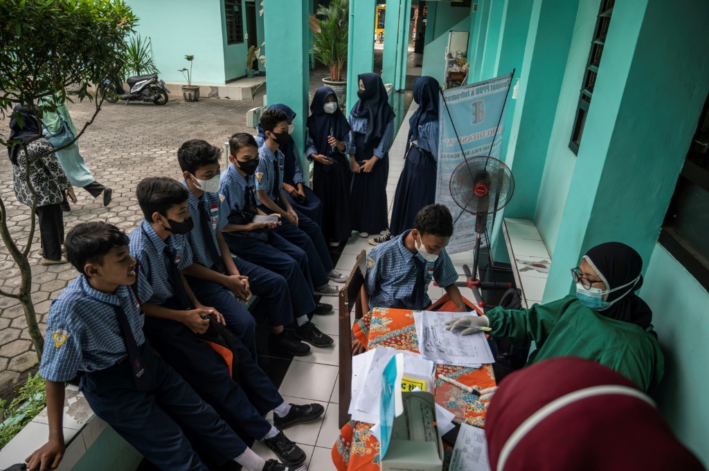 عاملة صحية تجري اختبارات كوفيد-19 سريعة لتلامذة في مدرسة تكميلية في سورابايا في اندونيسيا في التاسع من حزيران/يونيو 2022 (ا ف ب)