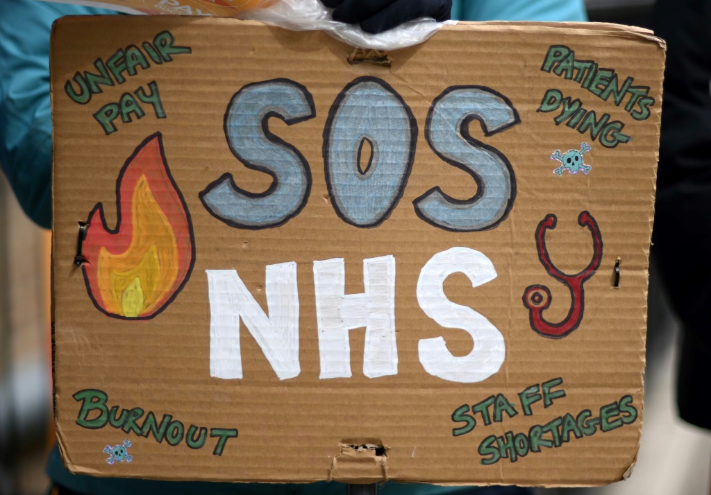 لافتة تطالب بإنقاذ نظام الرعاية الصحية في المملكة المتحدة خلال إضراب لأطباء في لندن في 12 نيسان/أبريل 2023 (ا ف ب)