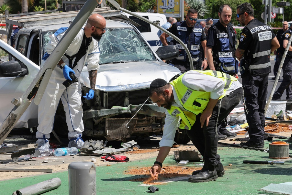 عناصر من الأمن والطوارئ الإسرائيليين يعملون في موقع هجوم بالدهس في تل أبيب في 4 تموز/يوليو 2023 (ا ف ب)