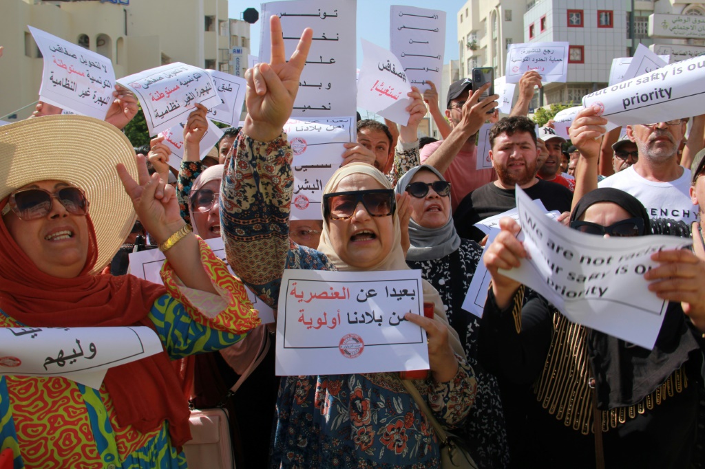 متظاهرون يرفعون لافتات خلال احتجاجهم على وجود مهاجرين غير شرعيين من إفريقيا جنوب الصحراء في مدينة صفاقس التونسية في 25 حزيران/يونيو 2023 (ا ف ب)