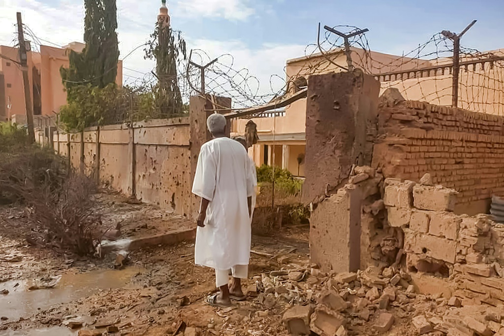     رجل سوداني يتفقد أضرار المعارك في ضاحية أم درمان في الخرطوم في الرابع من تموز/يوليو 2023 (أ ف ب)