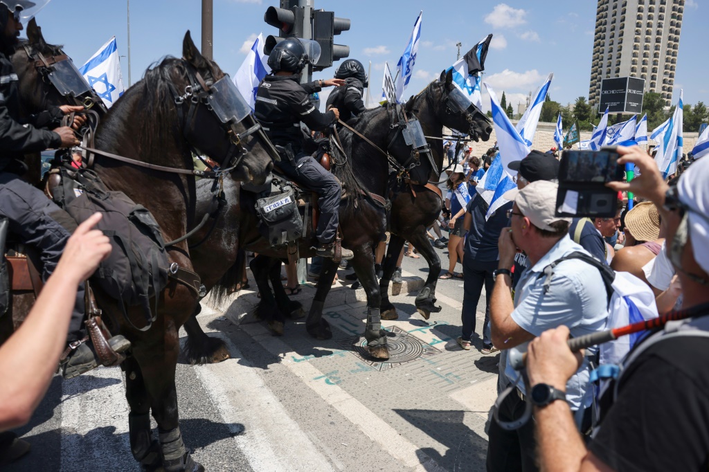     عناصر من الشرطة الإسرائليية يعتلون الأحصنة يحاولون تفريق المتظاهرين في القدس ضد خطة الإصلاح القضائي التي تبنتها الحكومة الإسرائيلية في 11 تموز/يوليو 2023 (أ ف ب)   