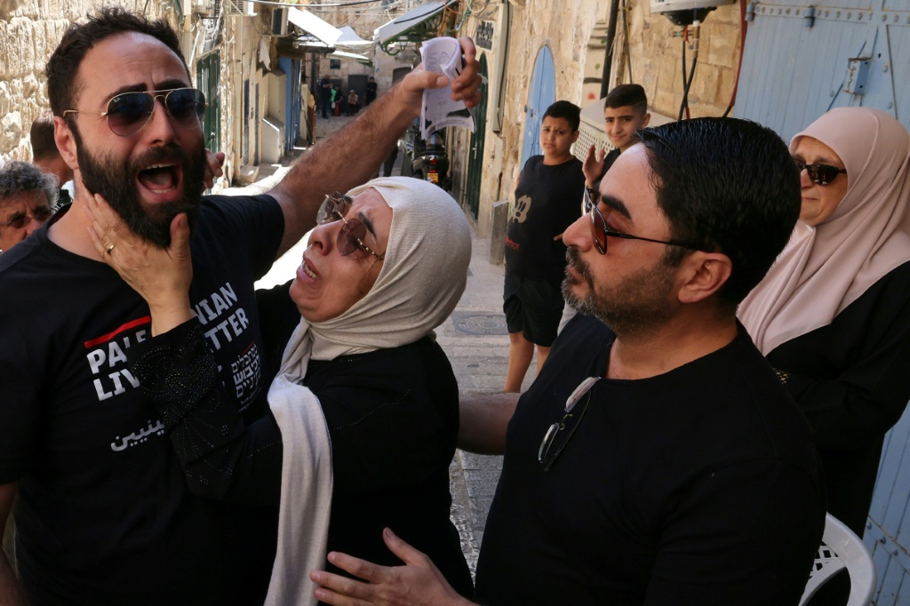نورا صب لبن وابناها رفعت (يسار) وأحمد أثناء إخلائهم من منزلهم في القدس الشرقية في 11 تموز/يوليو 2023 (ا ف ب)