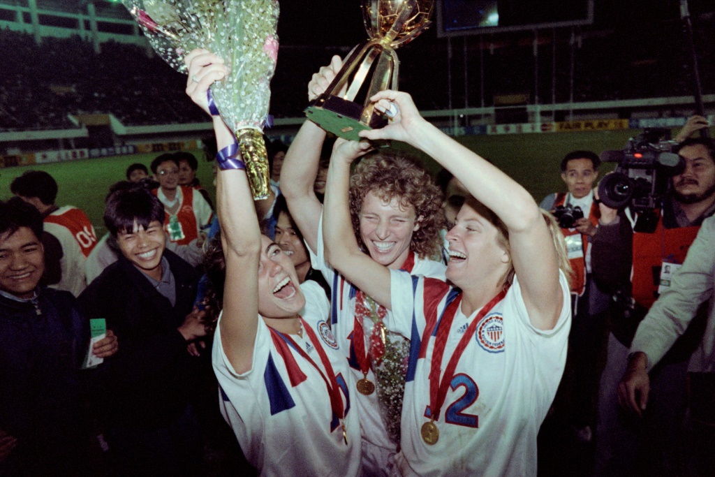 ميشال آيكرز (وسط) ترفع كأس العالم للسيدات مع المنتخب الاميركي بعد الفوز على النروج في النهائي في غوانغجو الصينية في 30 تشرين الثاني/نوفمبر 1991 (ا ف ب)