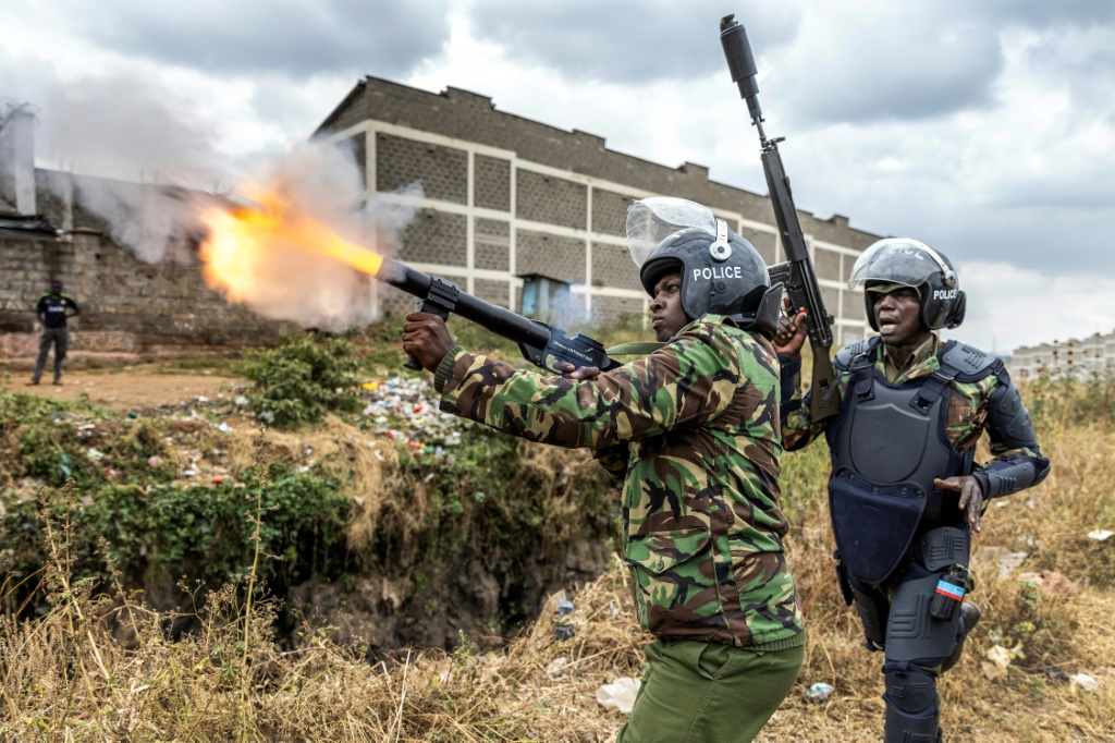        شرطي يطلق الغاز المسيل للدموع لتفريق المتظاهرين في نيروبي (أ ف ب)