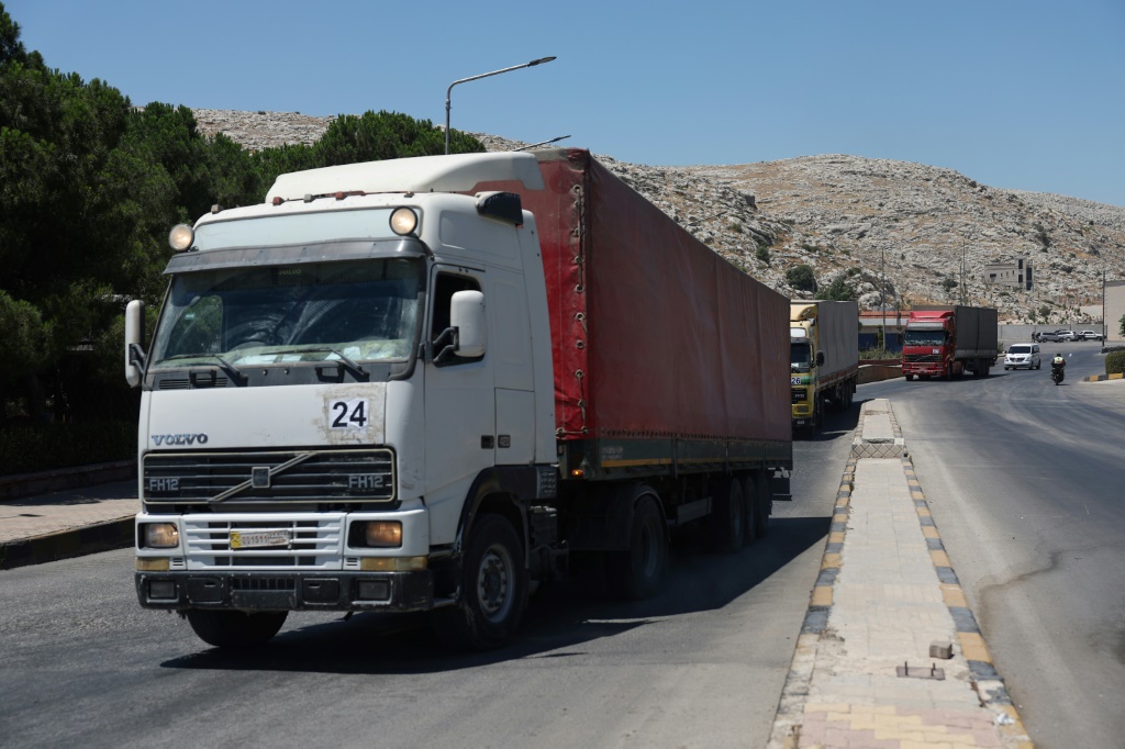 وصول قافلة تحمل مساعدات إنسانية إلى سوريا بعد عبورها معبر باب الهوى الحدودي مع تركيا ، في 10 تموز 2023 (ا ف ب)
