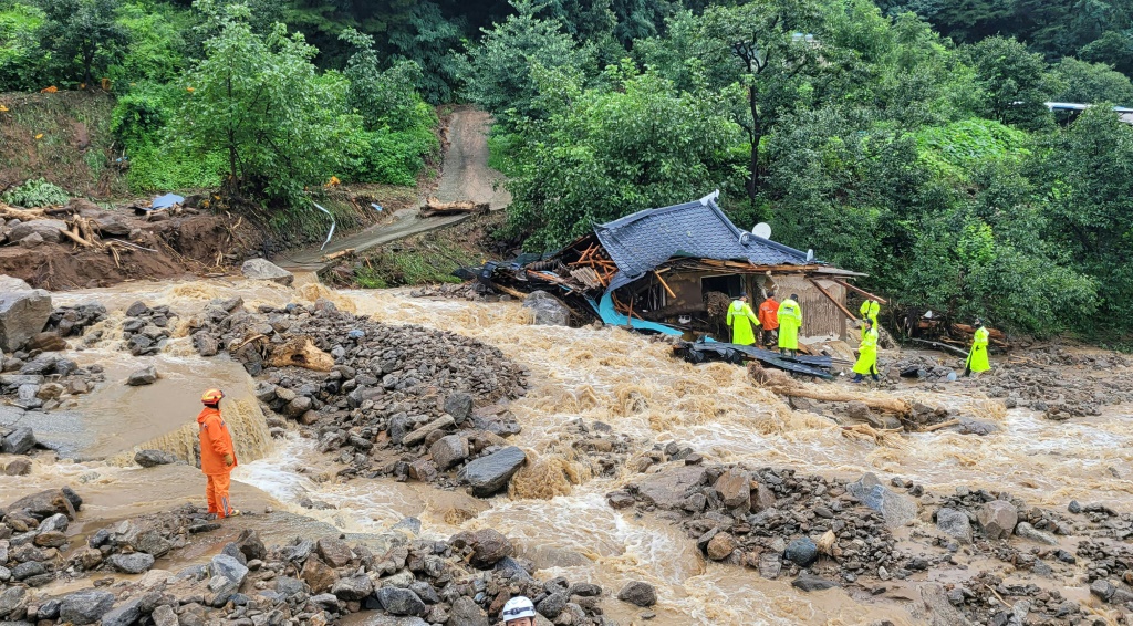 عمال الإنقاذ يبحثون عن ناجين في منزل دمرته الفيضانات بعد هطول أمطار غزيرة في يتشيون في كوريا الجنوبية في 15 تموز/يوليو 2023 (ا ف ب)