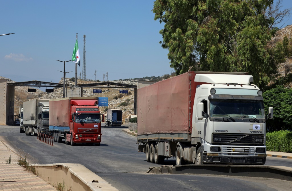 قافلة مساعدات تمر عبر معبر باب الهوى في شمال سوريا في 28 تموز/يوليو 2022 (ا ف ب)