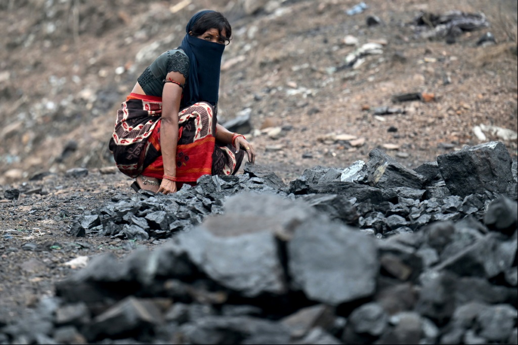 صورة تعود إلى السابع من تموز/يوليو 2023 لامرأة تجمع الفحم في منجم فحم مفتوح في ضواحي دانباد في ولاية جهارخاند الهندية (ا ف ب)