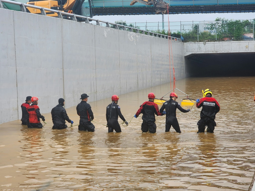 فريق إنقاذ أمام نفق علقت فيه سيارات بعدما اجتاحته المياه بعد فيضان نهر في شيونغجو بكوريا الجنوبية في 16 تموز/يوليو 2023 (ا ف ب)
