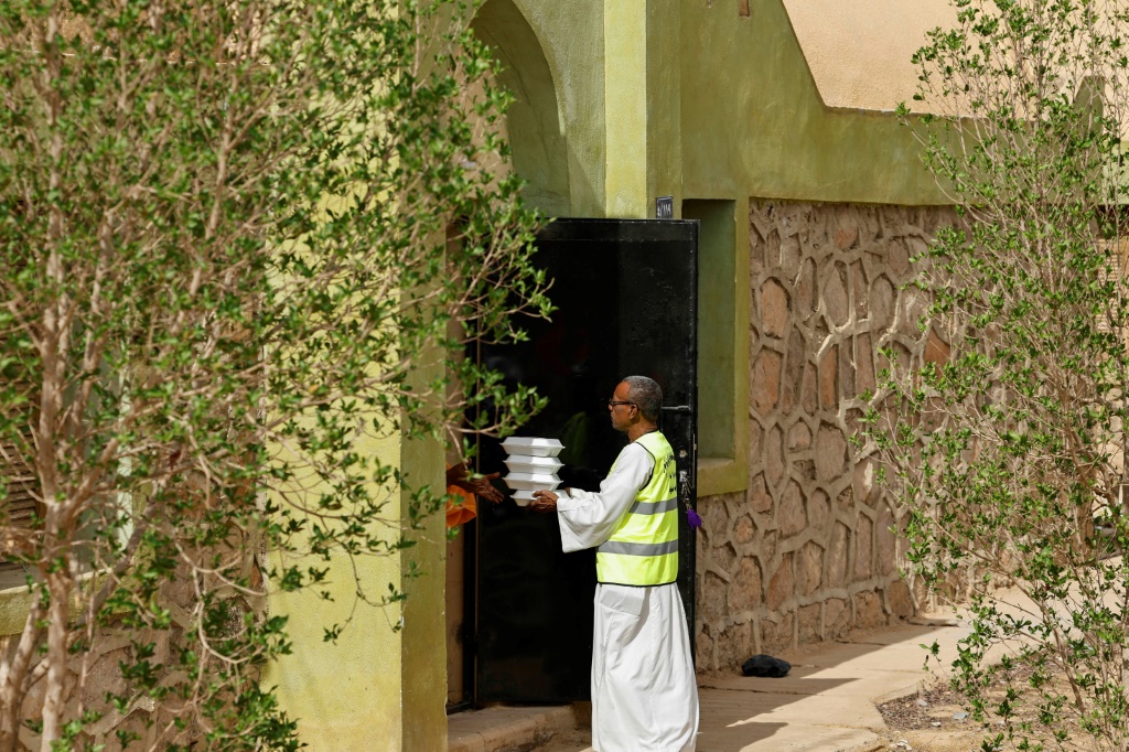 متطوع يسلم وجبات مجانية للاجئين سودانيين استضافتهم عائلة مصرية في قرية وادي كركر بالقرب من أسوان في 14 أيار/مايو 2023 (ا ف ب)