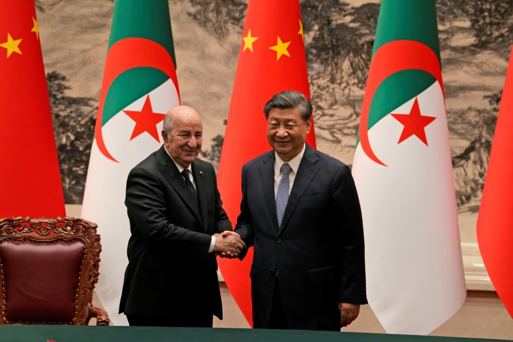 الرئيس الصيني شي جينبينغ (يمين) مصافحا نظيره الجزائري عبد المجيد تبون في بكين في 18 تموز/يوليو 2023 (ا ف ب)
