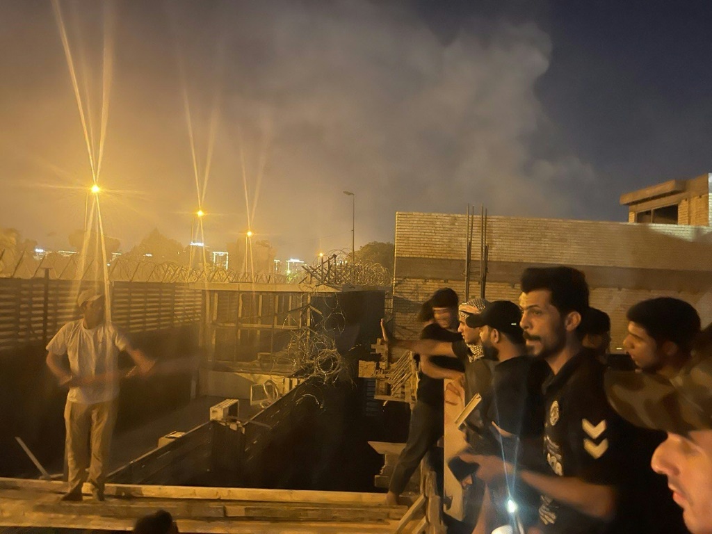 متظاهرون يقفون على مبنى قرب السفارة السويدية في بغداد في 20 تموز/يوليو 2023 (ا ف ب)