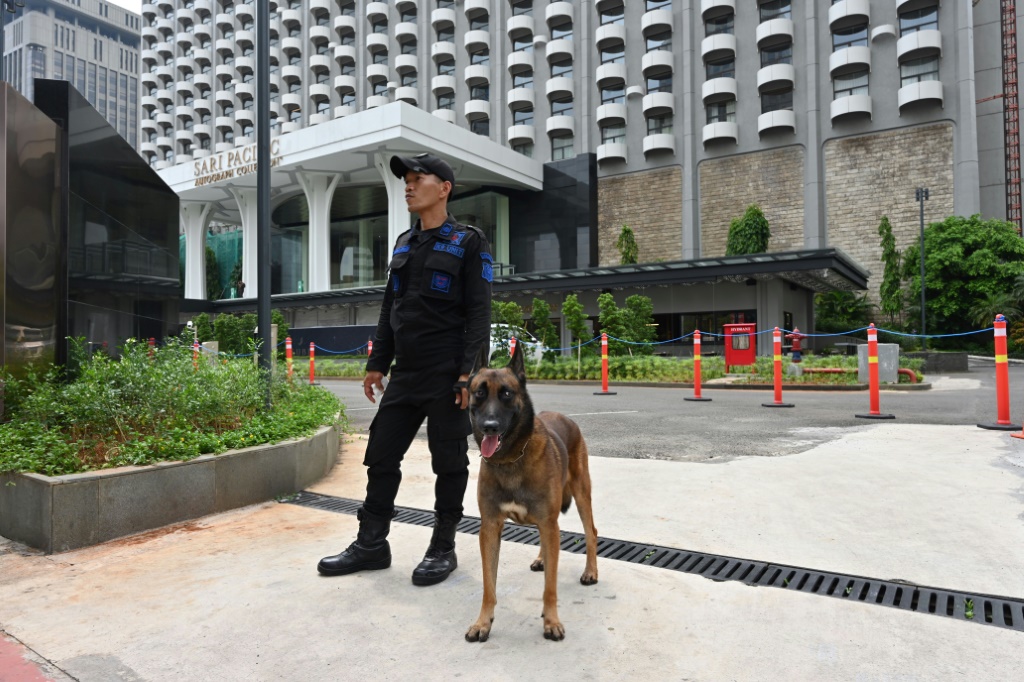 كلب حراسة مع شرطي في العاصمة الاندونيسية جاكرتا في الأول من أيار/مايو 2023 (ا ف ب)