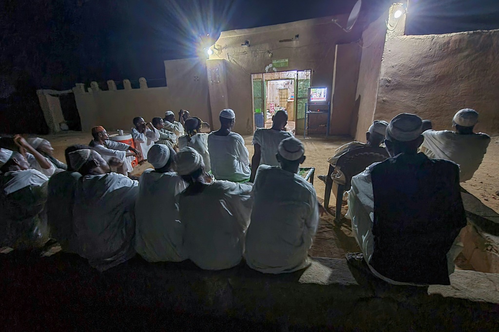 سودانيون يتابعون التلفزيون في محل للبقالة في أم درمان في 20 تموز/يوليو 2023 (ا ف ب)