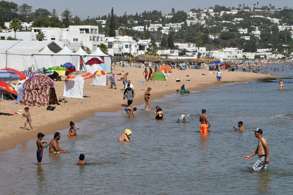 تونسون في شاطئ المرسى شمال العاصمة التونسية في ظل موجة حر شديد في 24 تموز/يوليو 2023 (ا ف ب)