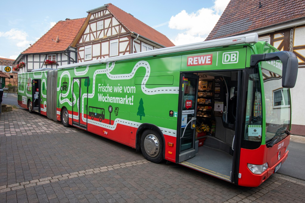 حافلة لشركة السكك الحديد الألمانية "دويتشه بان" تم تحويلها إلى سوبرماركت لمجموعة "ريفي" خلال توقفها في هادامار بوسط ألمانيا في 6 تموز/يوليو 2023 (ا ف ب)