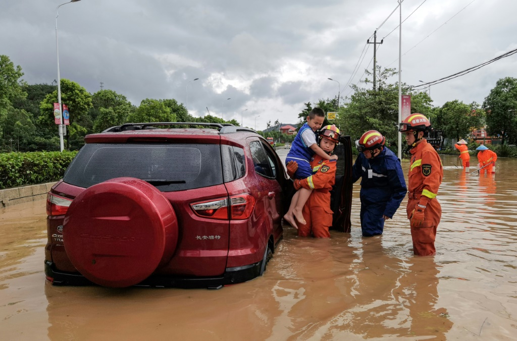 عمال إنقاذ يجلون سكاناً من منطقة غمرتها الفيضانات في أعقاب مرور الإعصار دوكسوري في مقاطعة فوجيان في شرق الصين في 28 تموز/يوليو 2023 (ا ف ب)