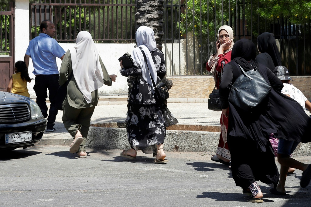 عائلات فلسطينية تخلي منازلها في مخيم عين الحلوة للاجئين الفلسطينيين في جنوب لبنان على خلفية اشتباكات بين حركة فتح واسلاميين في 30 تموز/يوليو 2023 (ا ف ب)